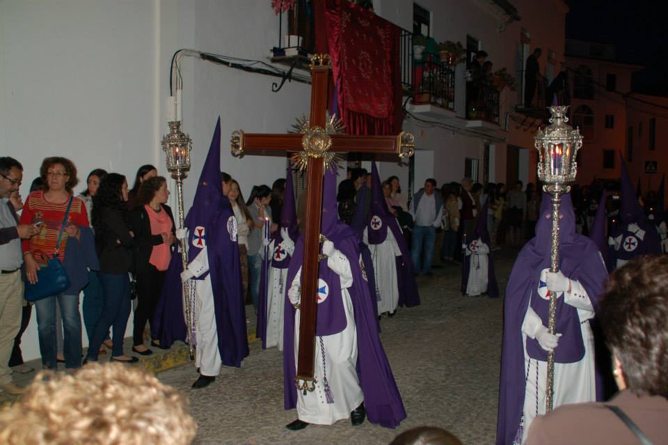 Nazarenos con capirotes morados en procesión nocturna durante la Semana Santa de Aracena